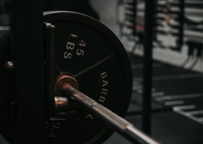 Detailed close-up of a heavy barbell loaded with a 45 lbs weight plate in a gym setting.