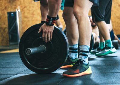 Close-up of a person lifting a barbell during a workout at a gym.