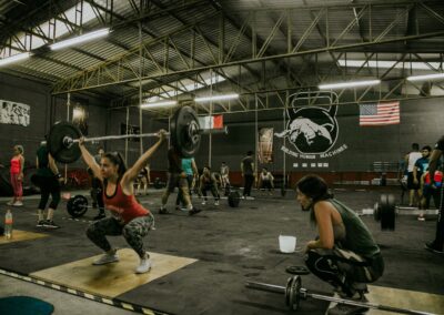 Diverse group engaging in CrossFit training in an industrial-style gym.
